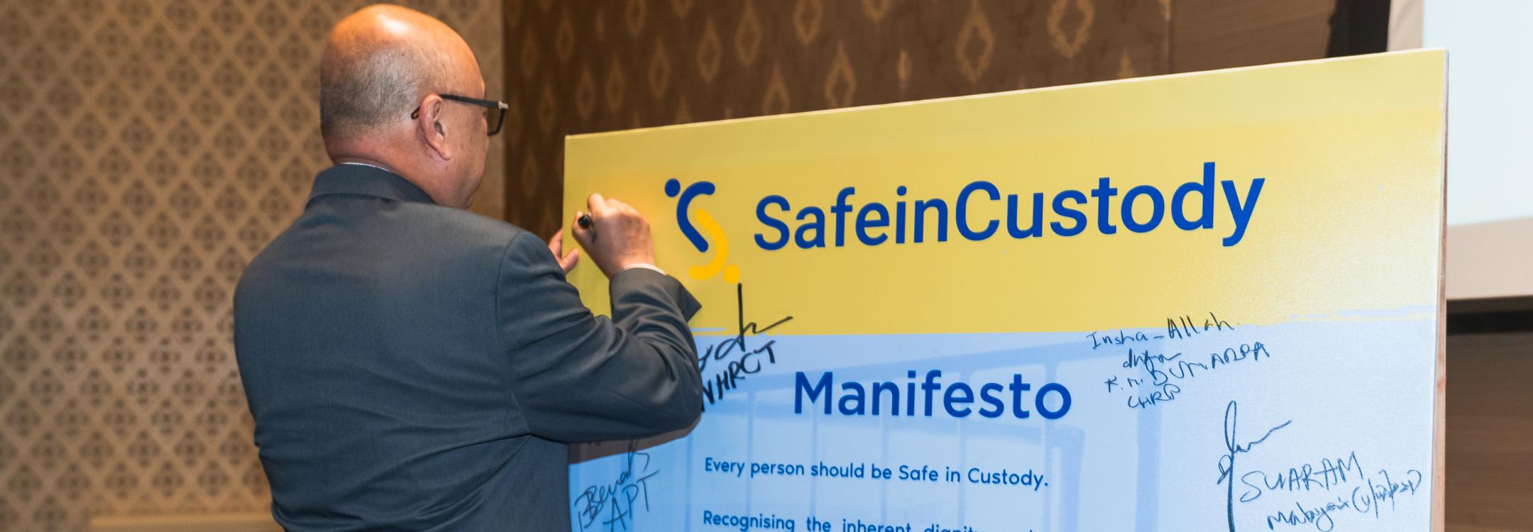 A conference participant signs the #SafeInCustody Manifesto